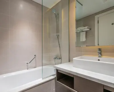 a bathroom with a tub and a sink and a shower at Phineek Elegant Studio Canal View Maison Prive Business Bay in Dubai