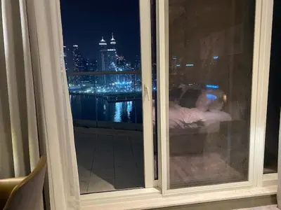 a window with a view of a city at night at Phineek Elegant Studio Canal View Maison Prive Business Bay in Dubai