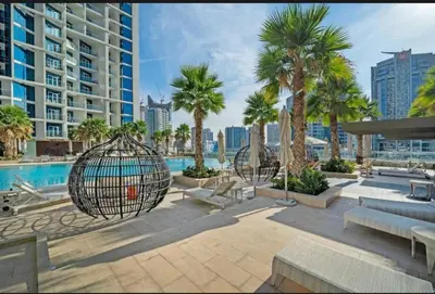 a resort with palm trees and a swimming pool at Phineek Elegant Studio Canal View Maison Prive Business Bay in Dubai