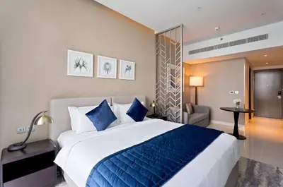 a bedroom with a large bed with blue pillows at Phineek Elegant Studio Canal View Maison Prive Business Bay in Dubai