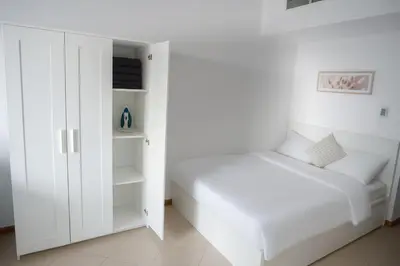 a white bedroom with a bed and a closet at Elite Studio at Dubai Marina in Dubai