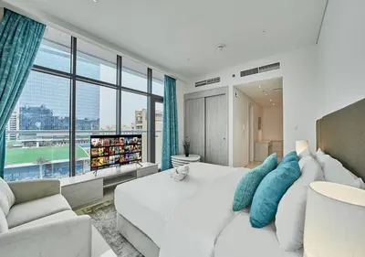 a bedroom with a white bed and a large window at First Class Apartments in Seven Palm with direct Access to the West Palm Beach and Nakheel Mall in Dubai