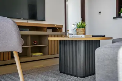 a living room with a table and a tv at Cute 1 BR - Walk to Opera, Mall & Burj Khalifa in Dubai