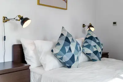 a bed with blue and white pillows on it at Cute 1 BR - Walk to Opera, Mall & Burj Khalifa in Dubai