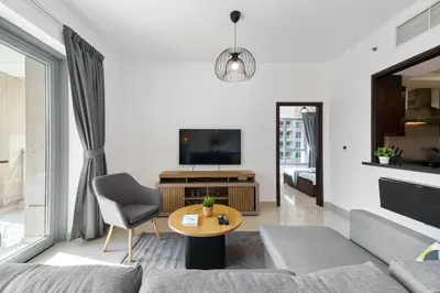 a living room with a couch and a table at Cute 1 BR - Walk to Opera, Mall & Burj Khalifa in Dubai