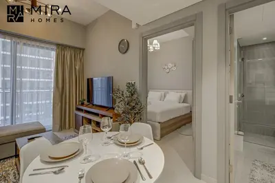 a living room with a dining table and a bedroom at Mira Holiday Homes - Serviced apartment in Zada Tower in Dubai
