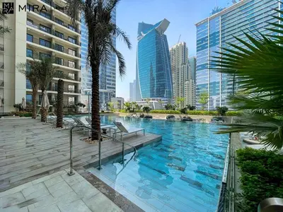 a large swimming pool in a city with tall buildings at Mira Holiday Homes - Serviced apartment in Zada Tower in Dubai