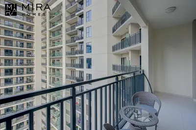 a balcony with two chairs and a building at Mira Holiday Homes - Serviced apartment in Zada Tower in Dubai