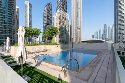 a swimming pool on the roof of a building with tall buildings at Chic 2-Bedroom Downtown Gem in Dubai