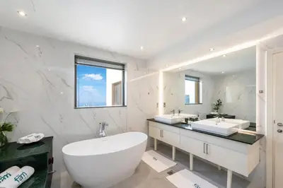 a bathroom with a large tub and a large mirror at FAM Living- Luxe Penthouse in JBR Marina - Panaromic Sea View in Dubai