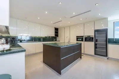 a large kitchen with white cabinets and a large island at FAM Living- Luxe Penthouse in JBR Marina - Panaromic Sea View in Dubai