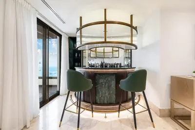 a bar with two green chairs and a chandelier at FAM Living- Luxe Penthouse in JBR Marina - Panaromic Sea View in Dubai