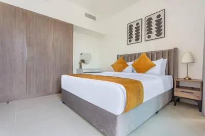 a bedroom with a large bed with orange pillows at Three Bedroom Villa with Maid Room in Tilal Al Ghaf by The S Holiday Homes in Dubai