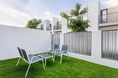 a group of chairs on a lawn in front of a building at Three Bedroom Villa with Maid Room in Tilal Al Ghaf by The S Holiday Homes in Dubai