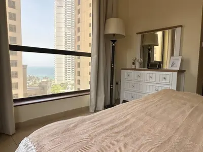 a bedroom with a bed and a large window at Sun, Sand, and FUN - King Bed, Sofa Bed! Sleeps 4 in Dubai
