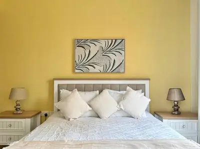a bedroom with a bed with white pillows and two lamps at Sun, Sand, and FUN - King Bed, Sofa Bed! Sleeps 4 in Dubai