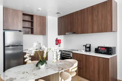 a kitchen with a table and a refrigerator at Spacious 1 bed in La Mer - 1 min to the beach in Dubai