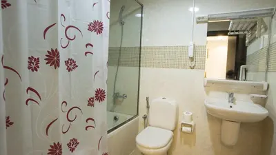 a bathroom with a toilet and a sink and a shower curtain at Flexible Small Partition Room Near MOE in Dubai