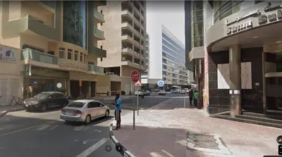 a person standing next to a stop sign on a city street at Brand New Private Partition Near MOE Metro in Dubai