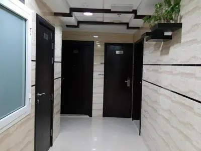 a hallway with two black doors in a building at Brand New Private Partition Near MOE Metro in Dubai