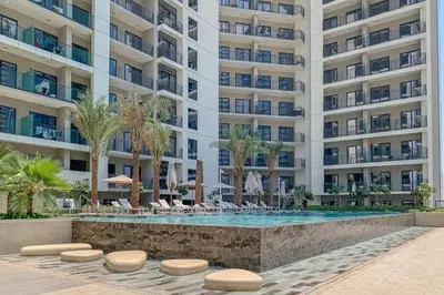a swimming pool in front of a large building at Stylish Apartment in Dubai