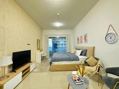 a bedroom with a bed and a tv in a room at Comfy Studio w/ Balcony & Nice Design in Marina in Dubai