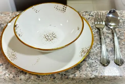 a plate and spoon and fork on a counter at Comfy Studio w/ Balcony & Nice Design in Marina in Dubai
