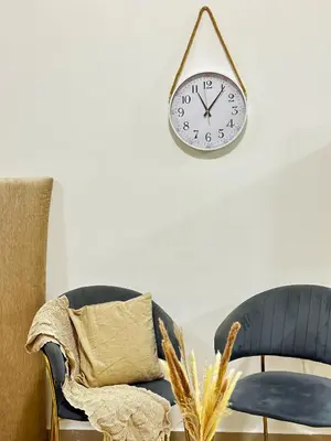 a clock hanging on a wall next to two chairs at Comfy Studio w/ Balcony & Nice Design in Marina in Dubai
