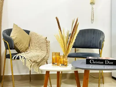 a living room with two chairs and a coffee table at Comfy Studio w/ Balcony & Nice Design in Marina in Dubai