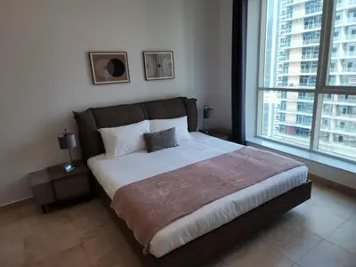 a bedroom with a large bed with two windows at Preatoni Tower - JLT by Golden Casa in Dubai