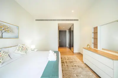 a white bedroom with a large bed and a window at Luton Vacation Homes - Tranquil 2BR Haven in the Heart of Dubai Marina- 28AB04 in Dubai