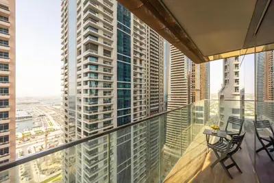 a balcony with chairs and a view of a city at Luton Vacation Homes - Tranquil 2BR Haven in the Heart of Dubai Marina- 28AB04 in Dubai