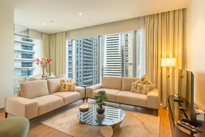 a living room with two couches and a large window at Luton Vacation Homes - Tranquil 2BR Haven in the Heart of Dubai Marina- 28AB04 in Dubai