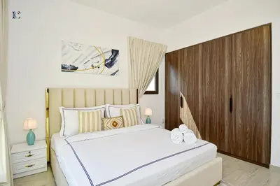 a bedroom with a white bed and a wooden cabinet at Luxury Escapes - Contemporary 2BR Gem in Madinat Jumeirah - RAHAAL in Dubai