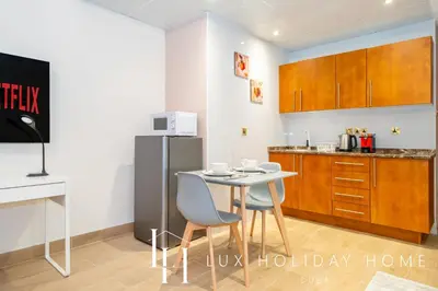 a kitchen with a table and chairs and a refrigerator at LUX The Marina View Suite 2 in Dubai