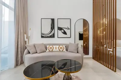 a living room with a couch and a glass table at Nice Studio in heart of JVC - Pantheon Elysée - Dubai in Dubai
