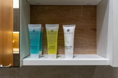 a shelf with four bottles of moisturizers on it at Nice Studio in heart of JVC - Pantheon Elysée - Dubai in Dubai