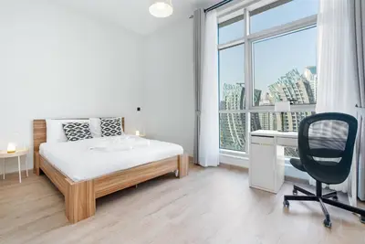 a bedroom with a bed and a desk and a window at Studio with Burj Khalifa View in Dubai