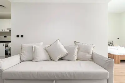 a white couch with many pillows on top of it at Studio with Burj Khalifa View in Dubai