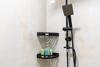a shower in a bathroom with a black shower head at Studio with Burj Khalifa View in Dubai