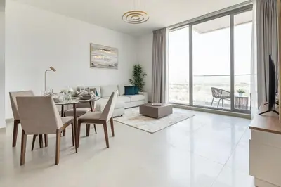 a white living room with a table and a couch at Frank Porter - Bluebell Residence in Dubai
