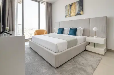 a bedroom with a large white bed with blue pillows at Frank Porter - Bluebell Residence in Dubai