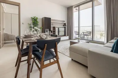 a living room with a dining room table and a couch at Frank Porter - Bluebell Residence JVC in Dubai