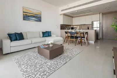 a living room and kitchen with a couch and a table at Frank Porter - Bluebell Residence JVC in Dubai