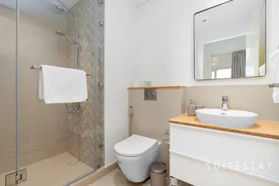 a bathroom with a toilet and a sink and a shower at Chic Bright One Bedroom Suite in Dubai