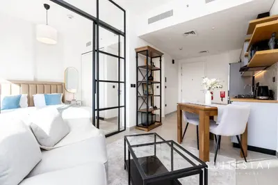 a living room with a white couch and a table at Chic Bright One Bedroom Suite in Dubai