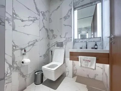 a bathroom with a toilet and a sink and a mirror at #37 Luxury - 2BR in The Address Dubai Opera - Downtown in Dubai