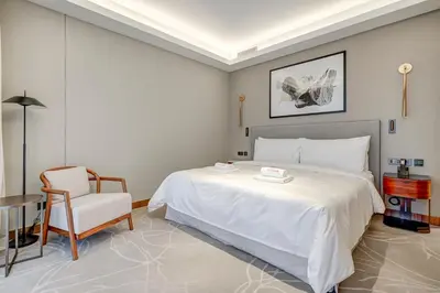 a bedroom with a large white bed and a chair at #37 Luxury - 2BR in The Address Dubai Opera - Downtown in Dubai