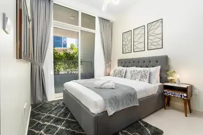 a bedroom with a large bed and a window at White Sage- Damac Vera Residences 417 in Dubai