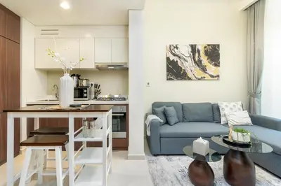 a living room with a blue couch and a table at White Sage- Damac Vera Residences 417 in Dubai